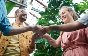 Grupo de pessoas a juntar os punhos em gesto de equipa