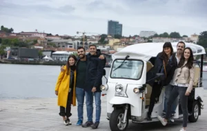 Grupo de 6 pessoas a pousar ao redor de um tuk tuk L5 Limo GT