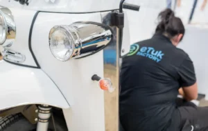 Pessoa a trabalhar na manutenção de um tuk tuk