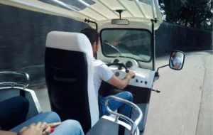 Motorista a conduzir um tuk tuk visto de trás